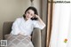 A woman in a white robe sitting on a chair.