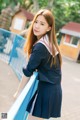 A woman in a school uniform is posing for a picture.