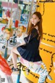 A young woman sitting on a carousel with a zebra.