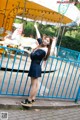 A woman in a school uniform standing in front of a carousel.