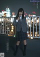 A woman in a school uniform standing on a balcony.