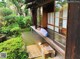 A woman sitting on a bench in a garden.