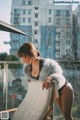 A woman in a fur coat leaning on a chair.