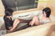 A couple of women sitting in a bathtub in a bathroom.