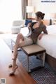 A woman sitting on a bench in a hotel room.