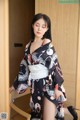 A woman in a black and white kimono posing for a picture.