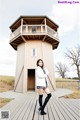 A woman standing in front of a wooden building.