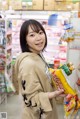 A woman holding a bag of food in a store.