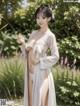 A woman in a white kimono standing in a garden.