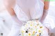 A woman in a wedding dress holding a bouquet of flowers.