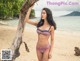 A woman in a bikini standing on a beach.