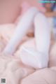 A woman laying on top of a bed wearing white stockings.