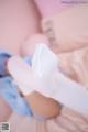 A baby laying on top of a bed wearing white socks.