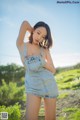 A woman in a denim dress posing for a picture.