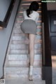 A woman in a skirt and high heels is walking up some stairs.