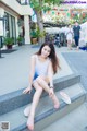 A woman sitting on the steps of a building with her feet up.