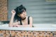 A woman in a bathtub with glasses on her face.