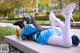 A woman in a blue and white outfit laying on a bench.