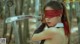 A woman in a red blindfold holding a sword.