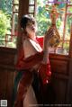 A woman in a red and green dress holding a musical instrument.