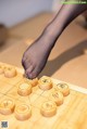 A person playing a game of chinese checkers on a wooden board.