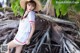 A woman in a white dress and a straw hat posing for a picture.