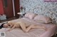 A naked woman laying on a bed in a bedroom.