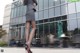 A woman in a gray dress and red high heels walking down the street.