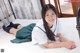 A woman in a school uniform laying on a bed.