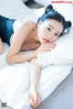 A woman laying on top of a bed next to a pillow.