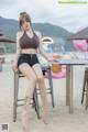 A woman sitting on top of a stool on a beach.