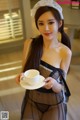 A woman in lingerie holding a cup of coffee.