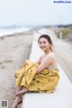 A woman sitting on a wall on the beach.