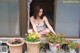 A woman sitting on a porch next to potted plants.