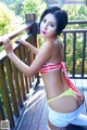 A woman in a bikini posing on a wooden deck.