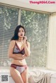 A woman in lingerie sitting on a window sill.