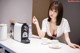 A woman sitting at a table with a cup of coffee.