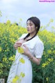 A woman in a field of yellow flowers.