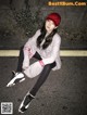 A woman sitting on the ground wearing a red hat.