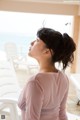 A woman sitting on a beach looking out at the ocean.