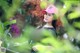 A woman wearing a pink hat sitting on a bench.