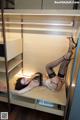 A woman laying on top of a desk in a closet.