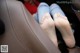 A woman's feet are sitting in the back seat of a car.