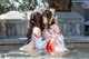 A couple of women sitting next to each other in a pool.