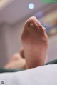 A close up of a person's foot on a bed.