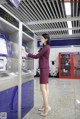 A woman standing in front of an atm machine.