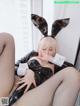 A woman in a bunny costume is sitting on a couch.