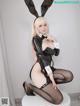 A woman in a bunny costume sitting on a stool.