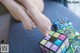 A woman sitting on a couch holding a rubik's cube.