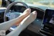 A woman's feet on the steering wheel of a car.